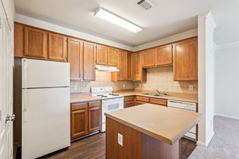 A kitchen with wooden cabinets and white appliances.